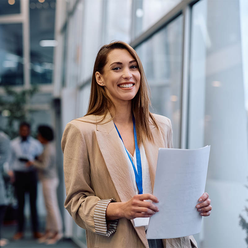 Happy female business seminar presenter looking at camera. Portrait of happy public speaker during business conference looking at camera.